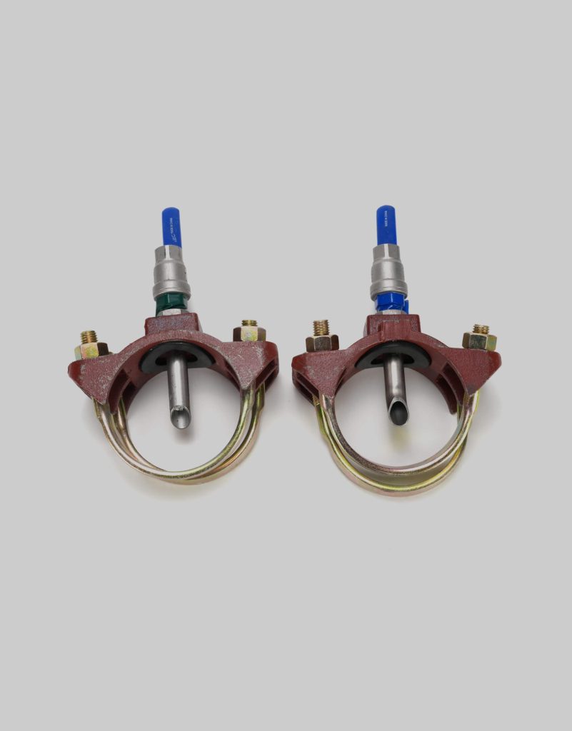 Two identical metal pipe clamps, model 1129, with attached valves and bolts are positioned side by side on a plain gray background.
