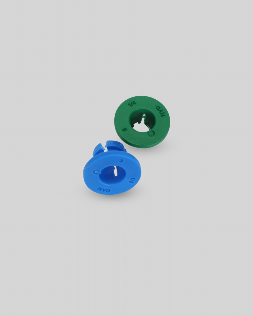 Two plastic drywall anchors, import placeholder,1137, one green marked "1/4" and one blue marked "3/16", are displayed on a plain light gray background.