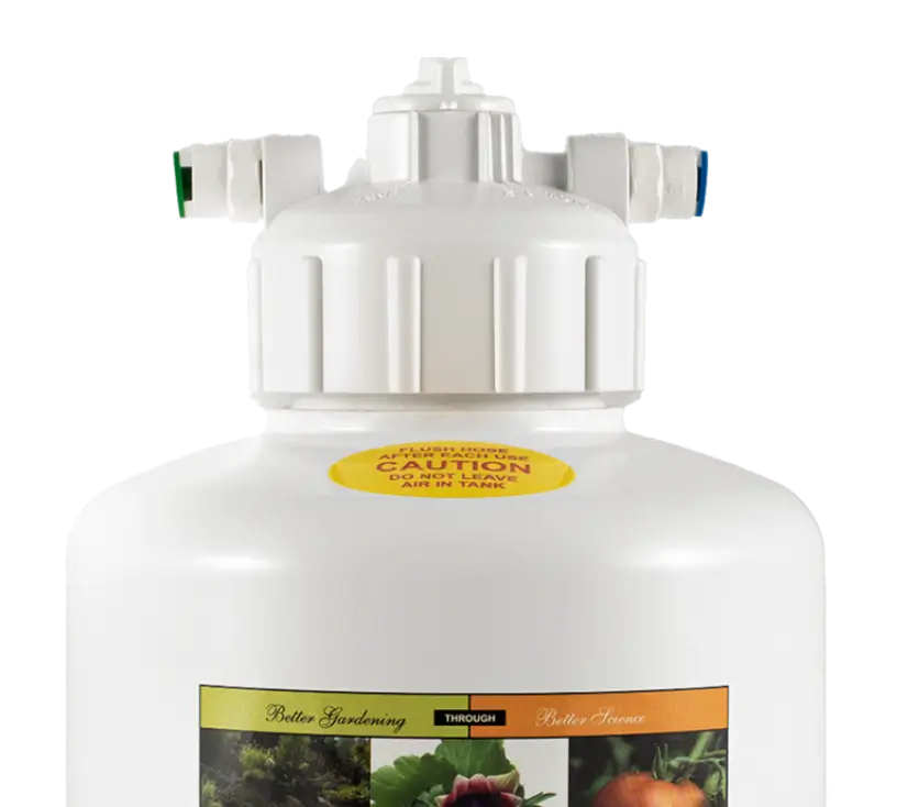 Close-up of a white plastic garden sprayer tank with caution label and multiple colored spray nozzle attachments on the lid.